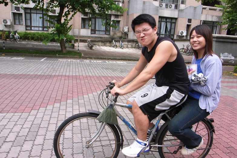 two people that are sitting on top of a bicycle