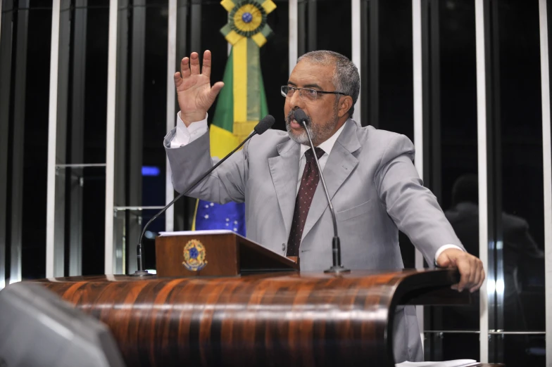 a man standing at a podium with his arms outstretched