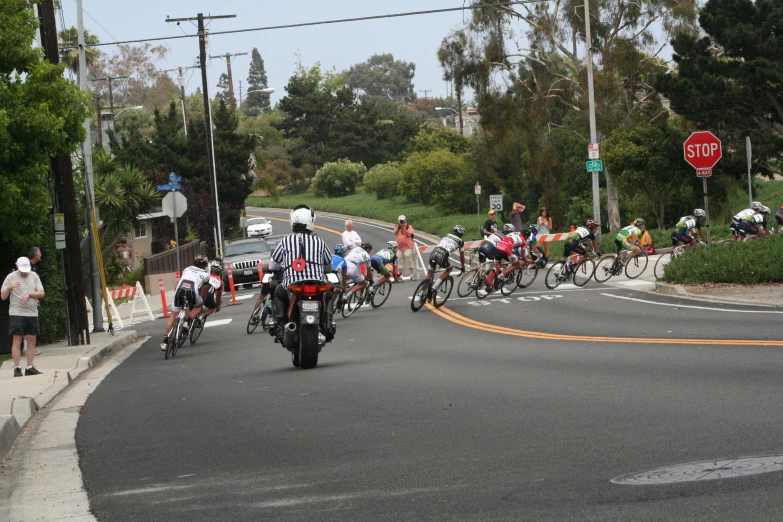 group of people on motorcycles passing by a red stop sign