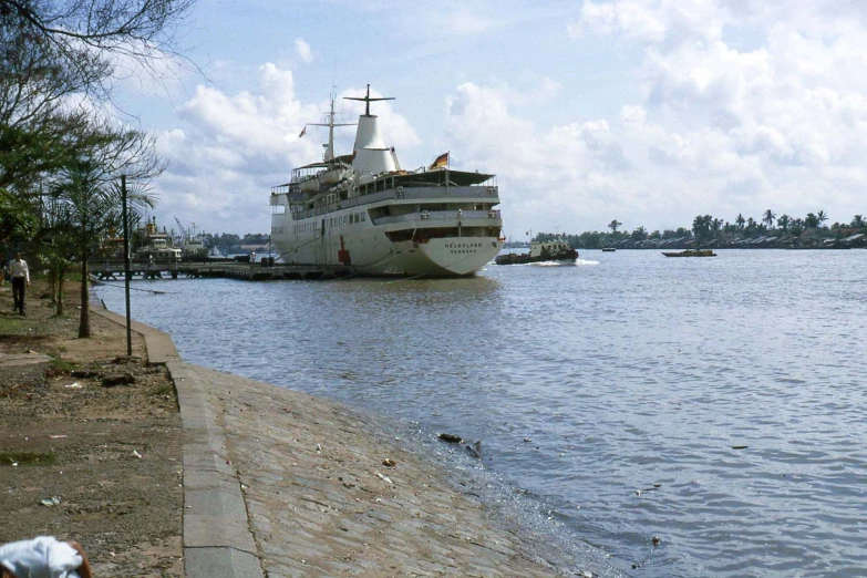 the white ship is anchored by some water