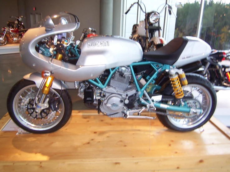 a white and blue motorcycle parked in a show room