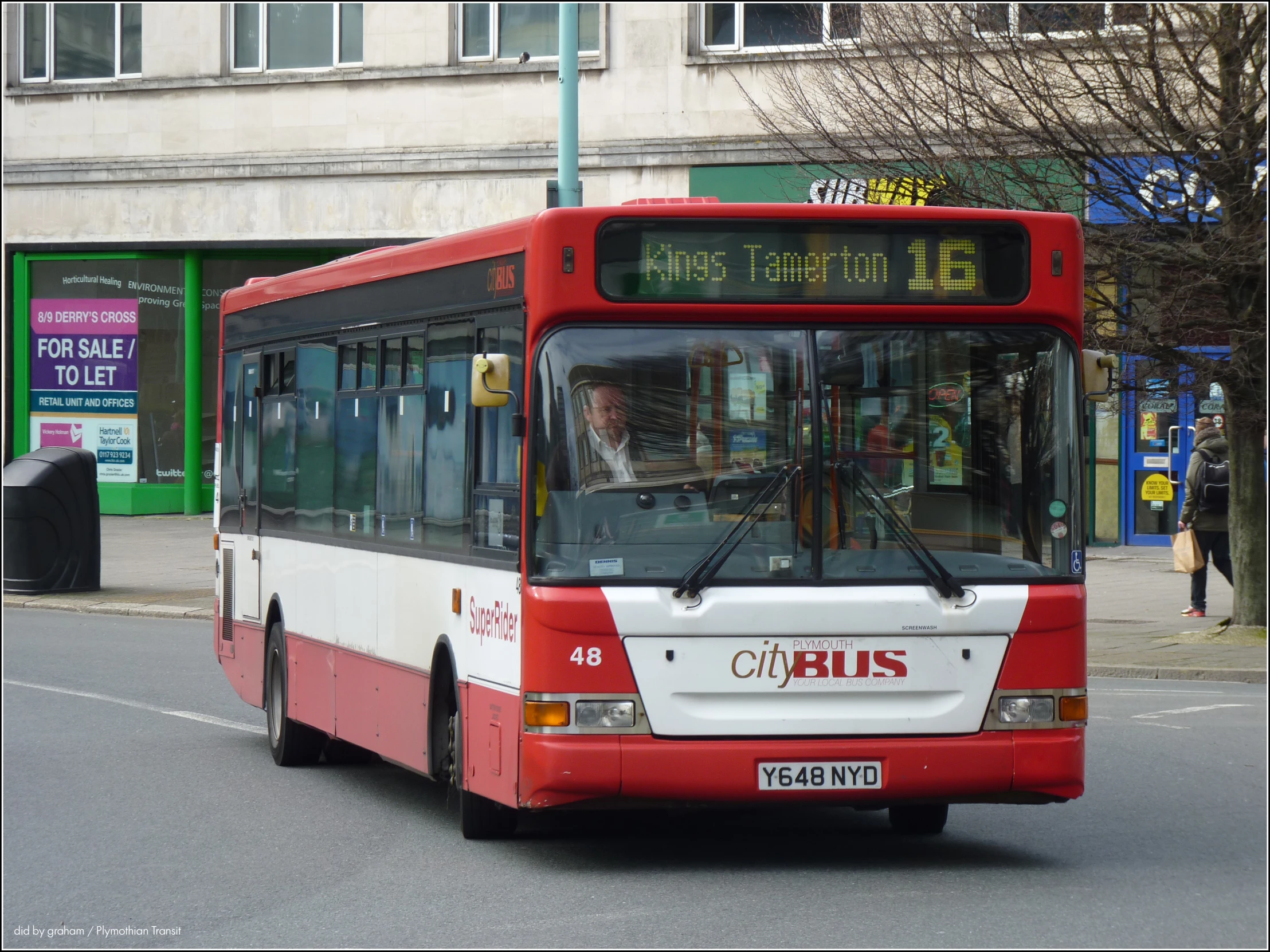 a passenger bus on the street near some buildings