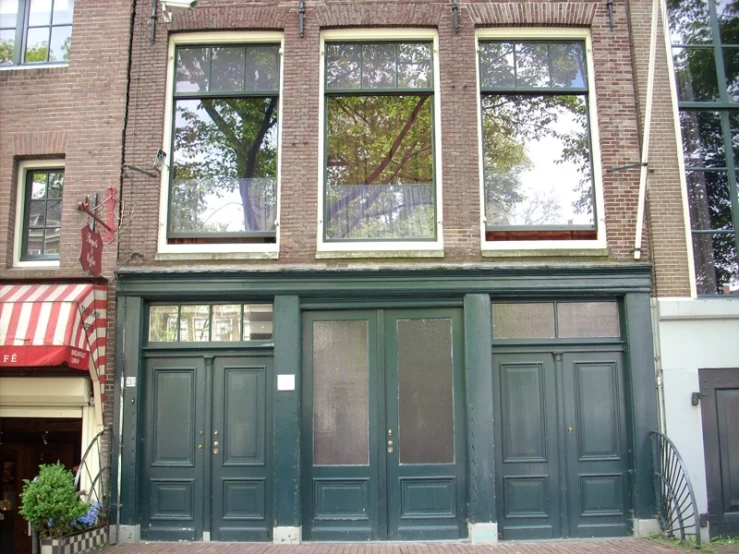 a two story brick building with a red and white striped awning