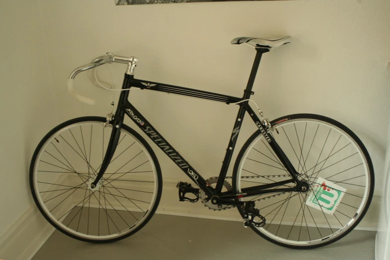 a bike parked next to a white wall with a black frame