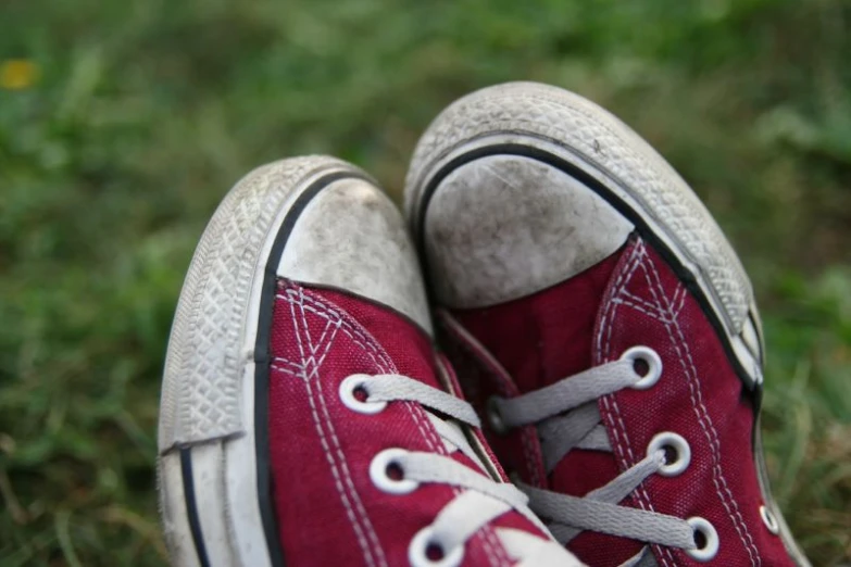 two red shoes sitting on top of each other on the grass