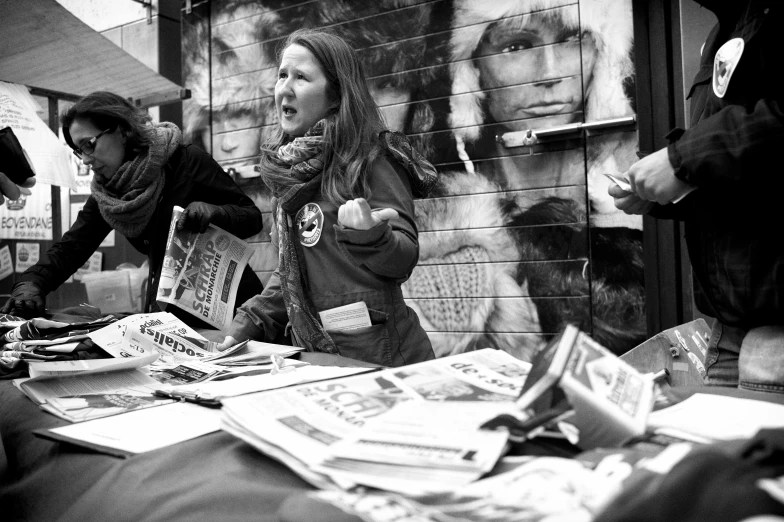 several people standing around a table covered in newspapers