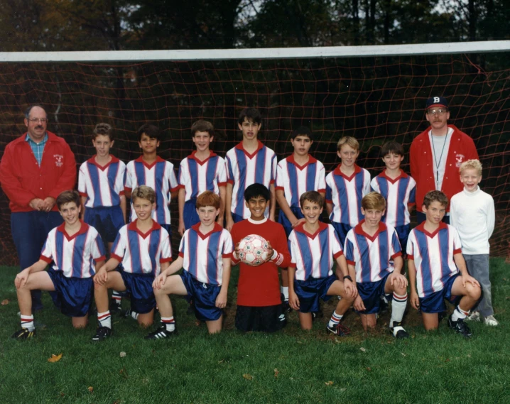 this group of children have their picture taken in front of the goal