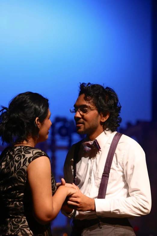 a woman and man on stage during a performance