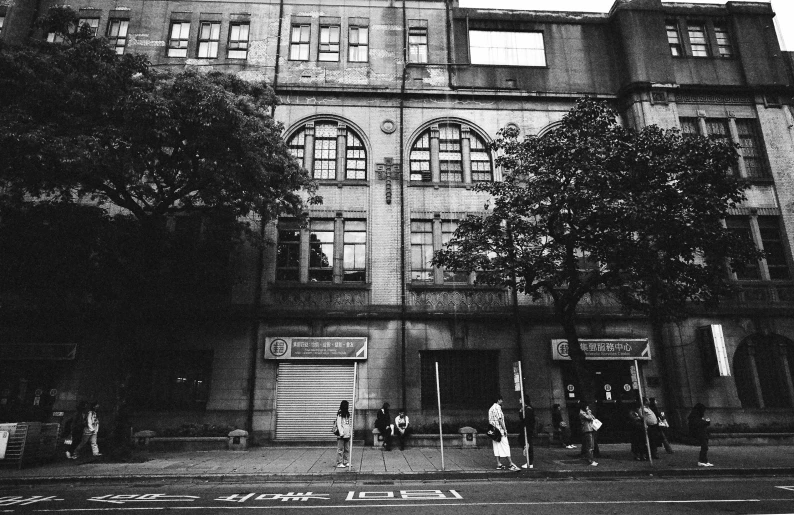 a black and white po of people walking near an old building