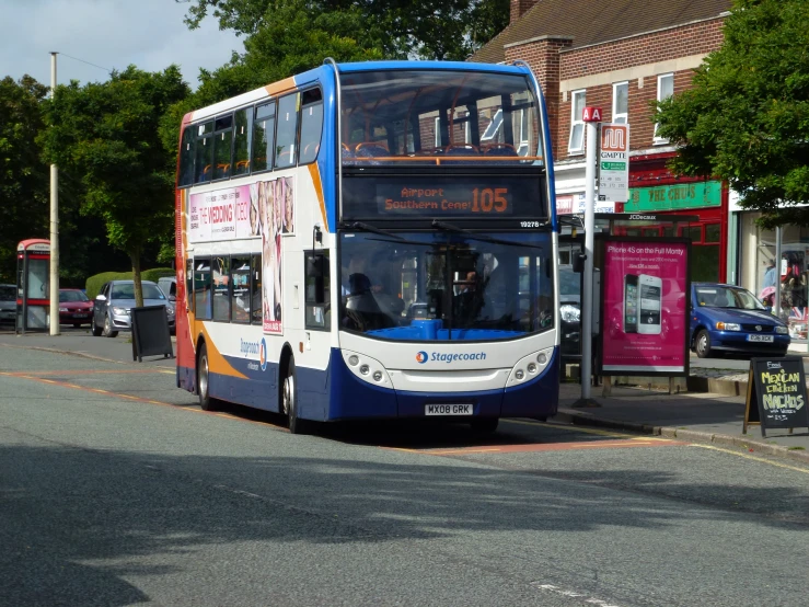 the double decker bus is driving down the road