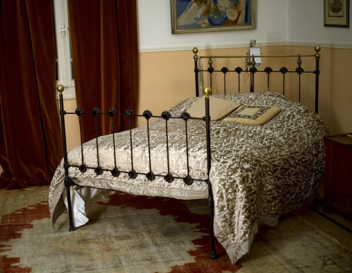 a wrought iron bed in the corner of an empty room