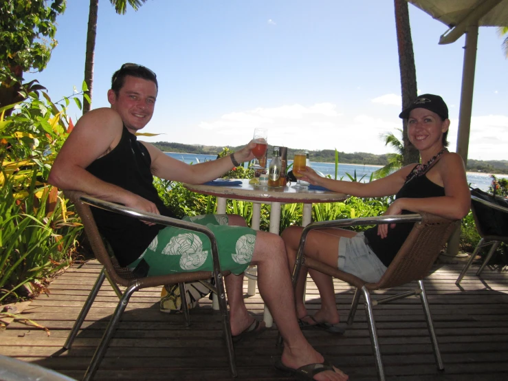 a man and woman enjoy drinks at an outdoor patio