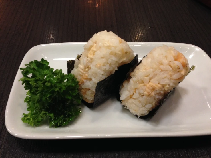 a sushi plate with two pieces of cut up sushi on top of it