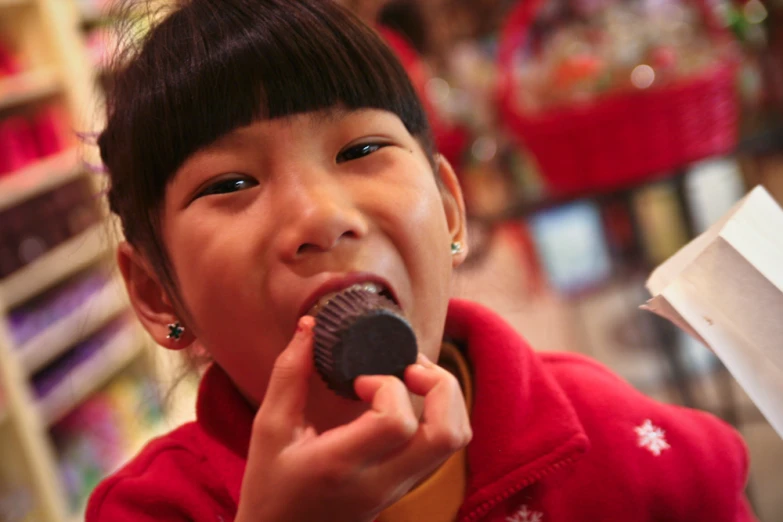 a young child eating soing chocolate in a market