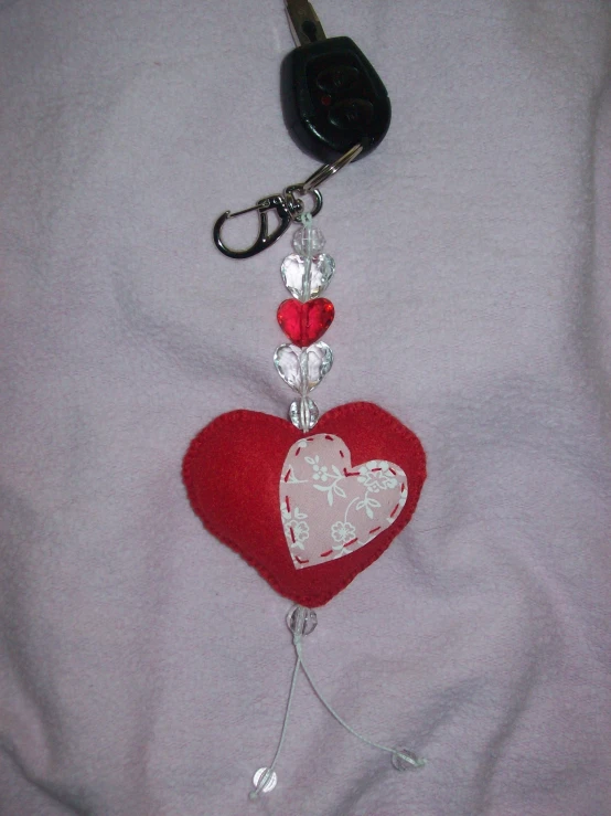 there is a keychain hanging from the top of a heart