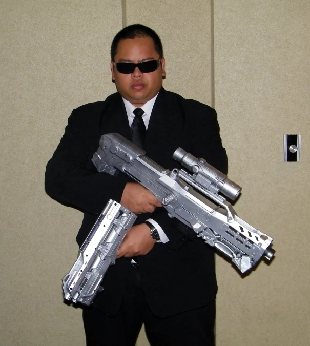 a man dressed in black holding an aluminum weapon