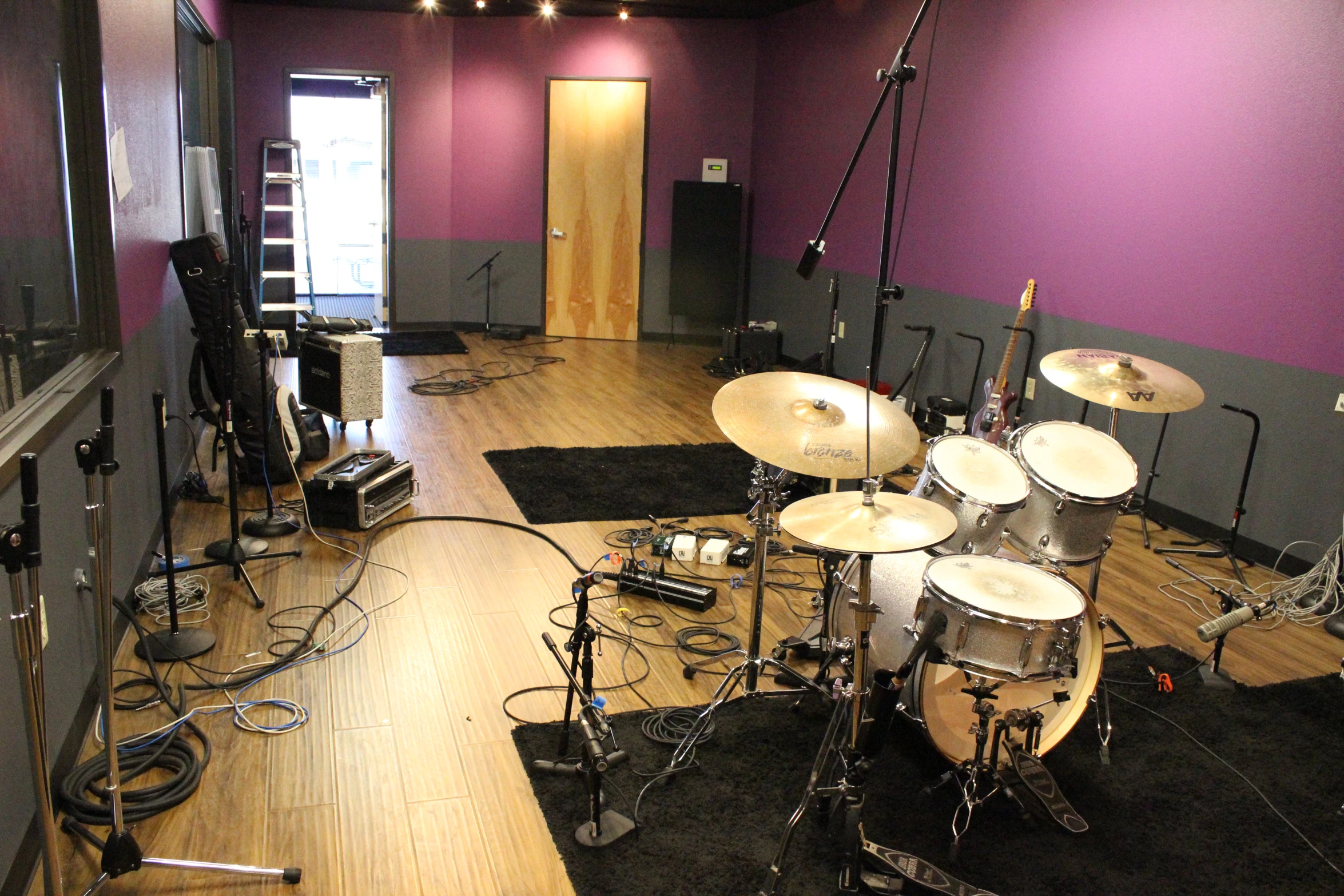 a drum set up in an empty studio space