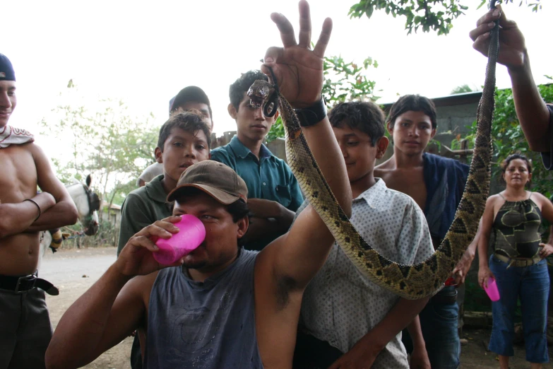 a man in pink drinking soing out of his mouth