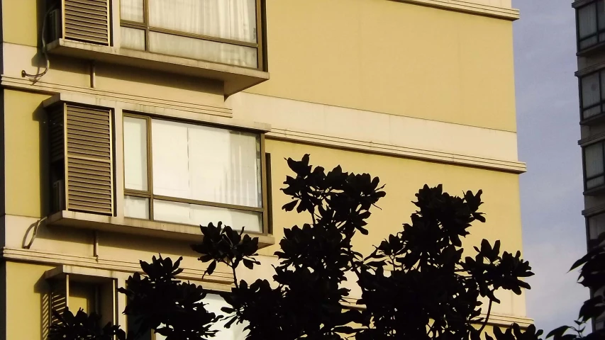 an apartment building has several window with blinds open