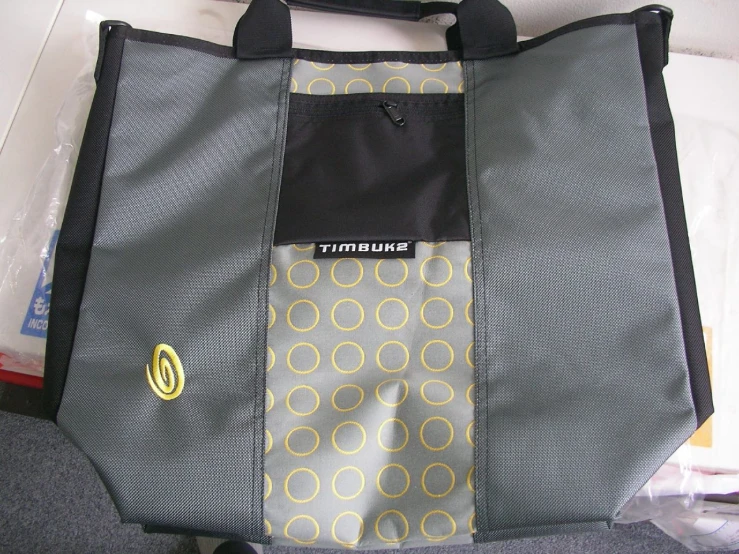 a grey bag with a yellow and black tie and two other items