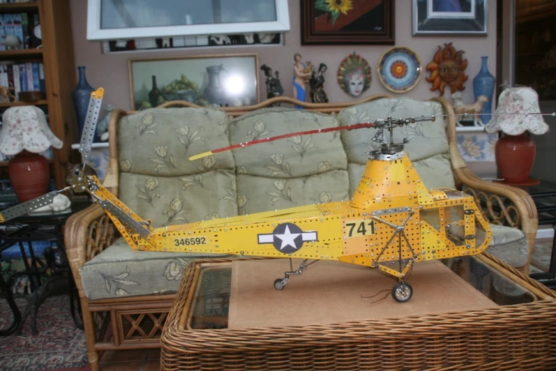a toy plane sitting in front of a wicker couch