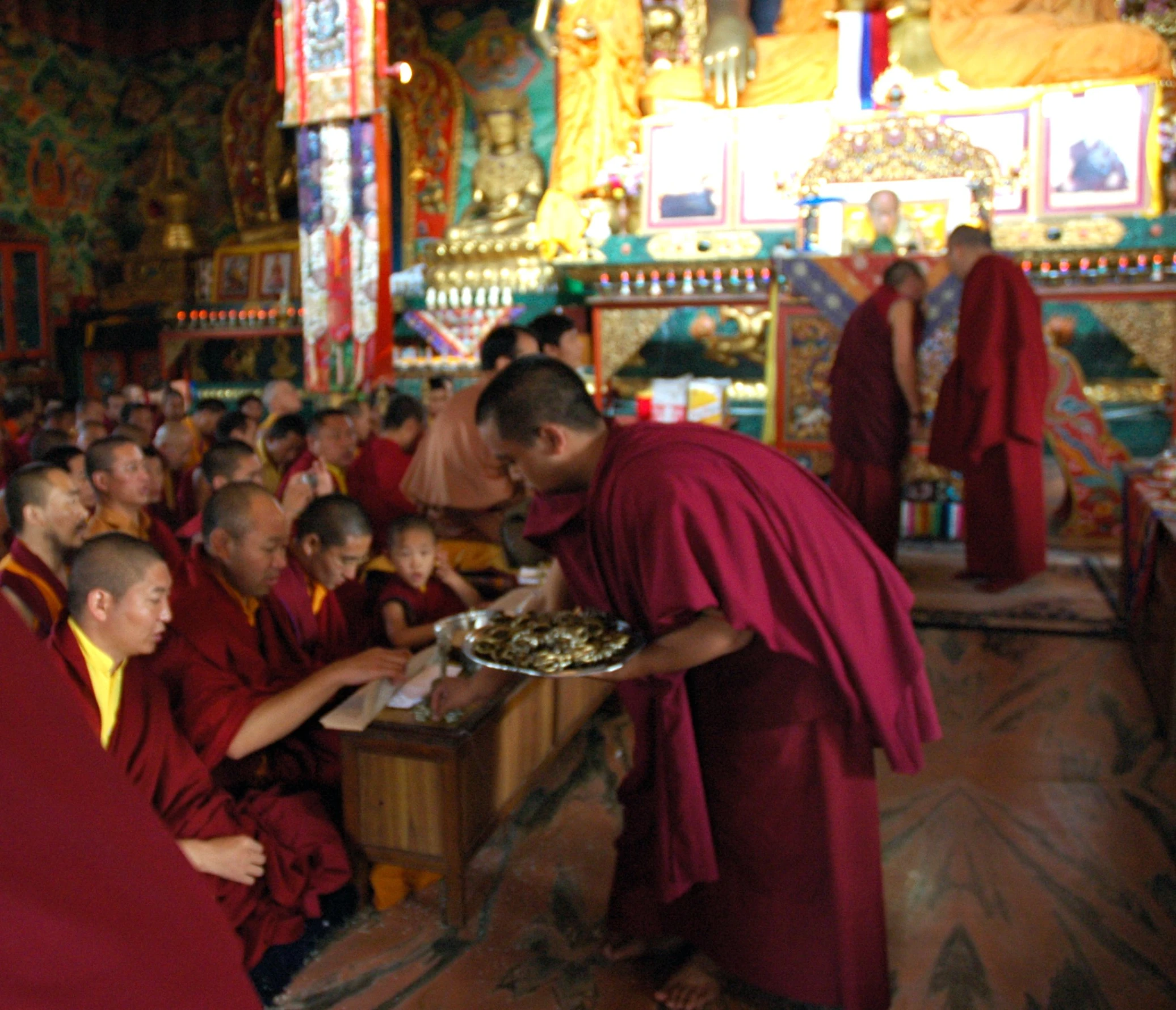 a monk giving food to a group of monks