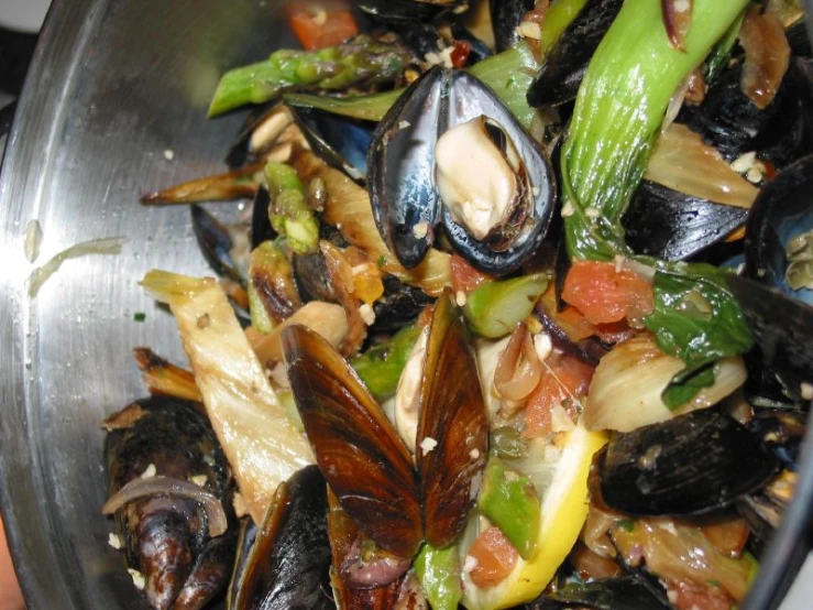 a pan full of cooked food including mussels and asparagus