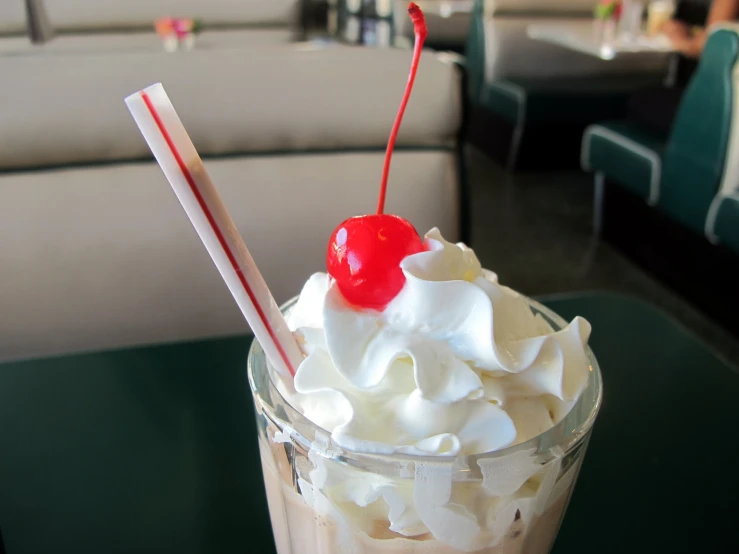 the drink is topped with whipped cream and a cherry