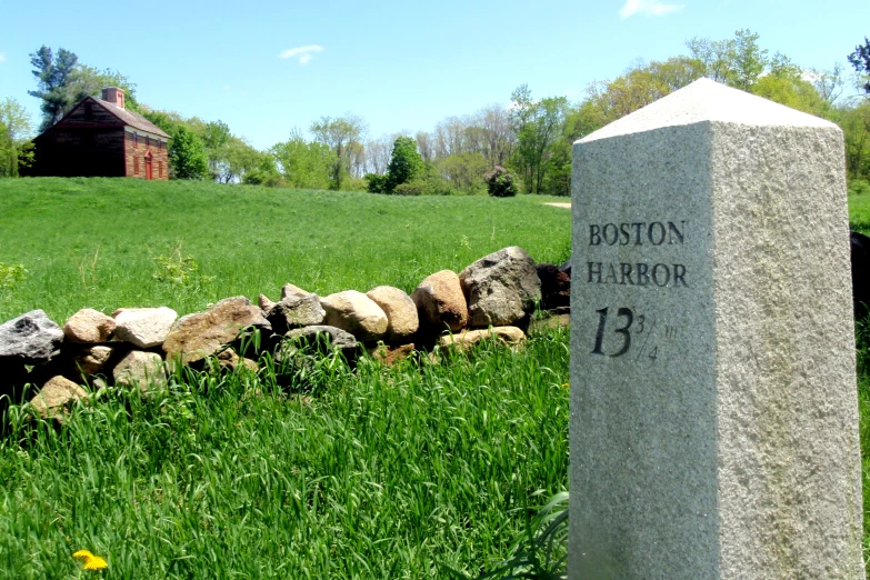 a grave with rocks surrounding it near some grass