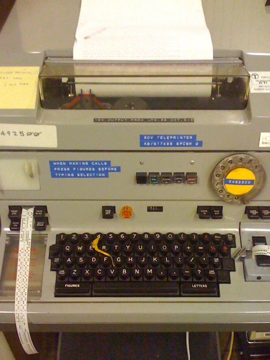 a old typewriter sitting on a table with some sticky papers