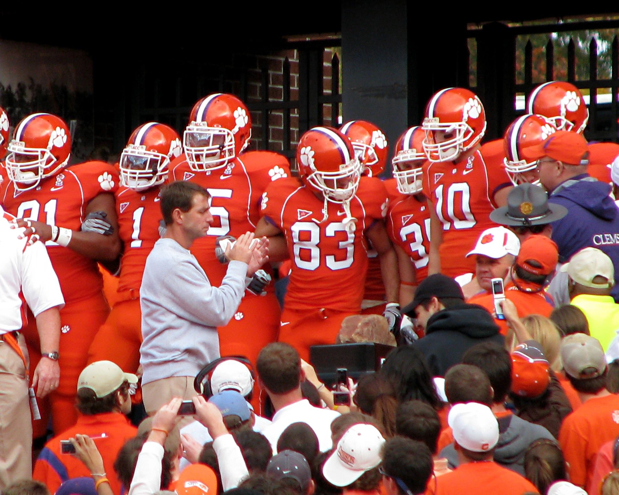 coach of football on sidelines talking to the media