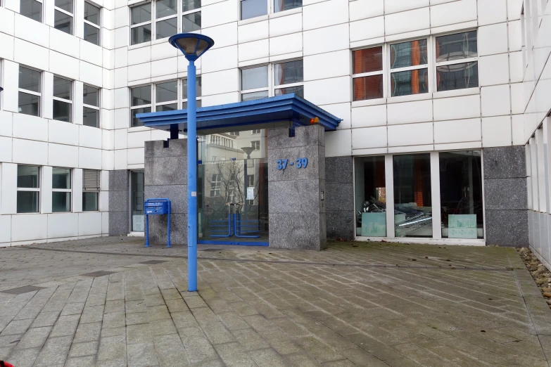 a blue lamp post sitting in front of an apartment building