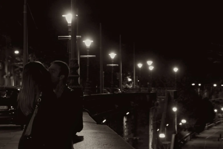 the couple kiss in front of a lamppost