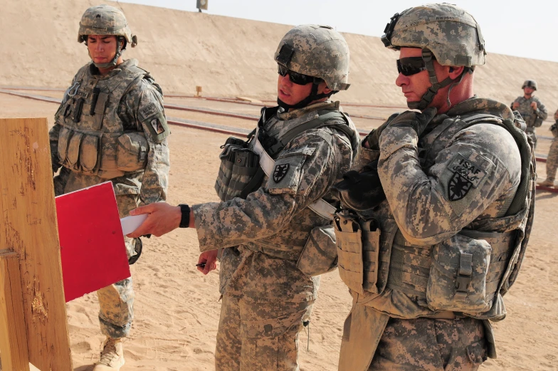 men in uniform talking to each other in the desert