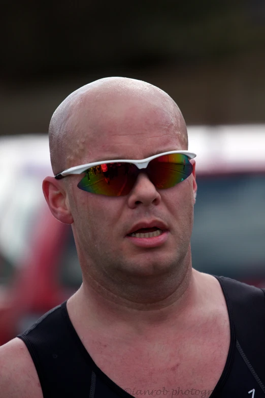 a bald man in a tank top with his sunglasses on
