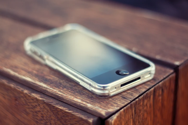 a cell phone is laying on a wooden table