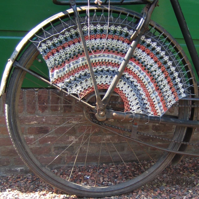 an old bike with a crocheted seat cover