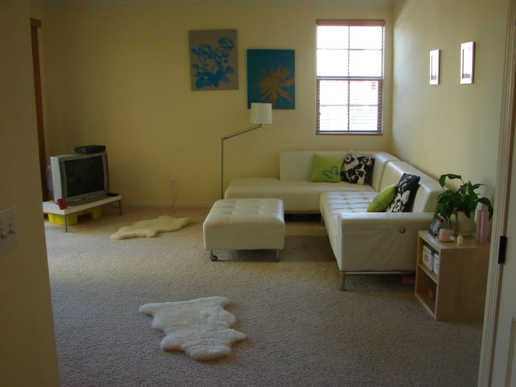 living room area with white sofa, chair and ottoman