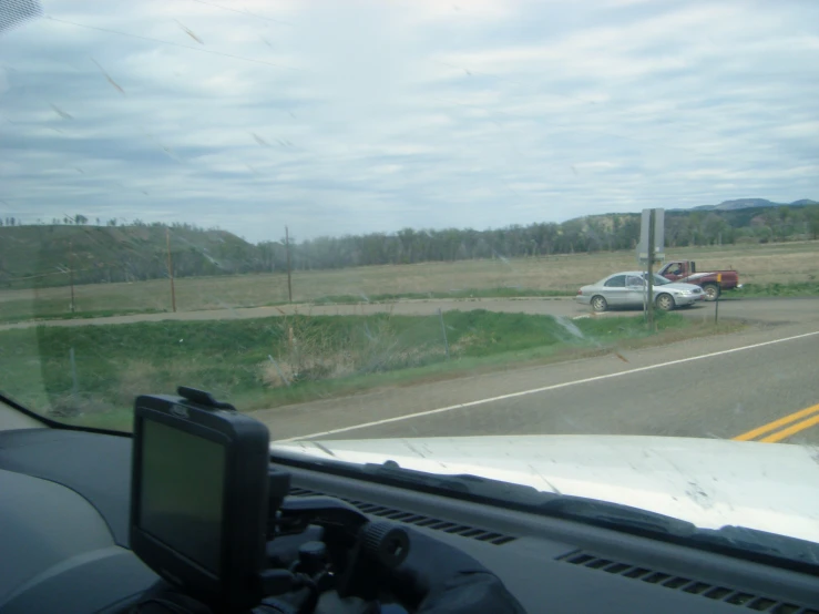 view out the car window to a road, a stop sign, and a pickup truck