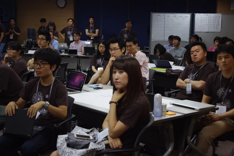 several young people are sitting at a desk