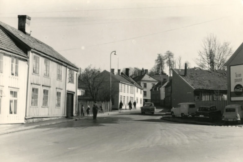 a group of people walking down a street near a row of buildings