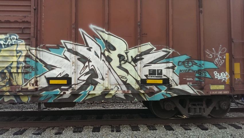 graffiti on a train car on tracks