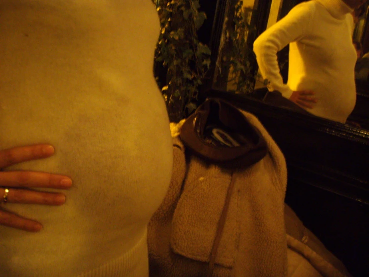a pregnant woman looking in the mirror of her belly