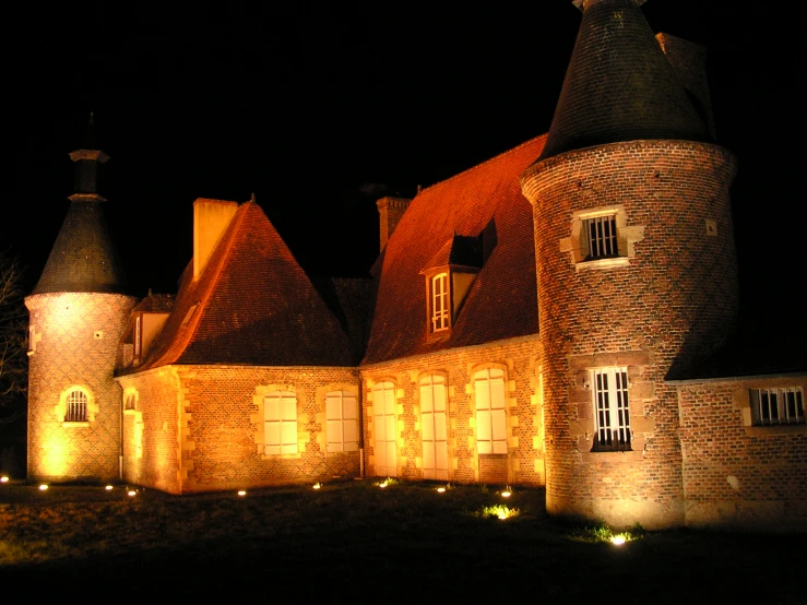 a castle with turrets is lit up at night