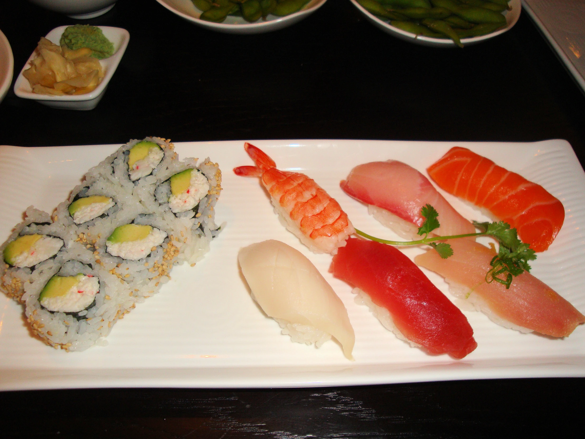 there is sushi on the plate, along with some asparagus and other vegetables