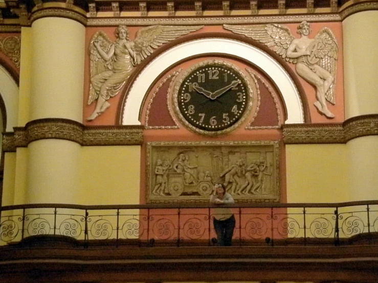 a wall clock above a staircase that is painted yellow