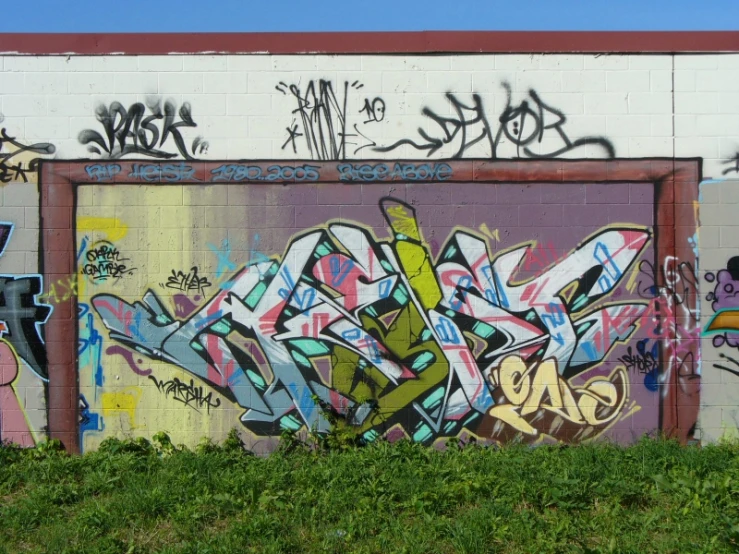 graffiti on a wall next to green grass