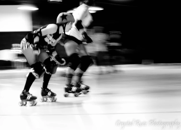 two people in protective gear skating down a ice rink