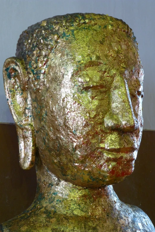 a golden head statue of a person with his eyes closed