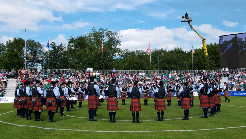 some men in kilts and ties are on a field